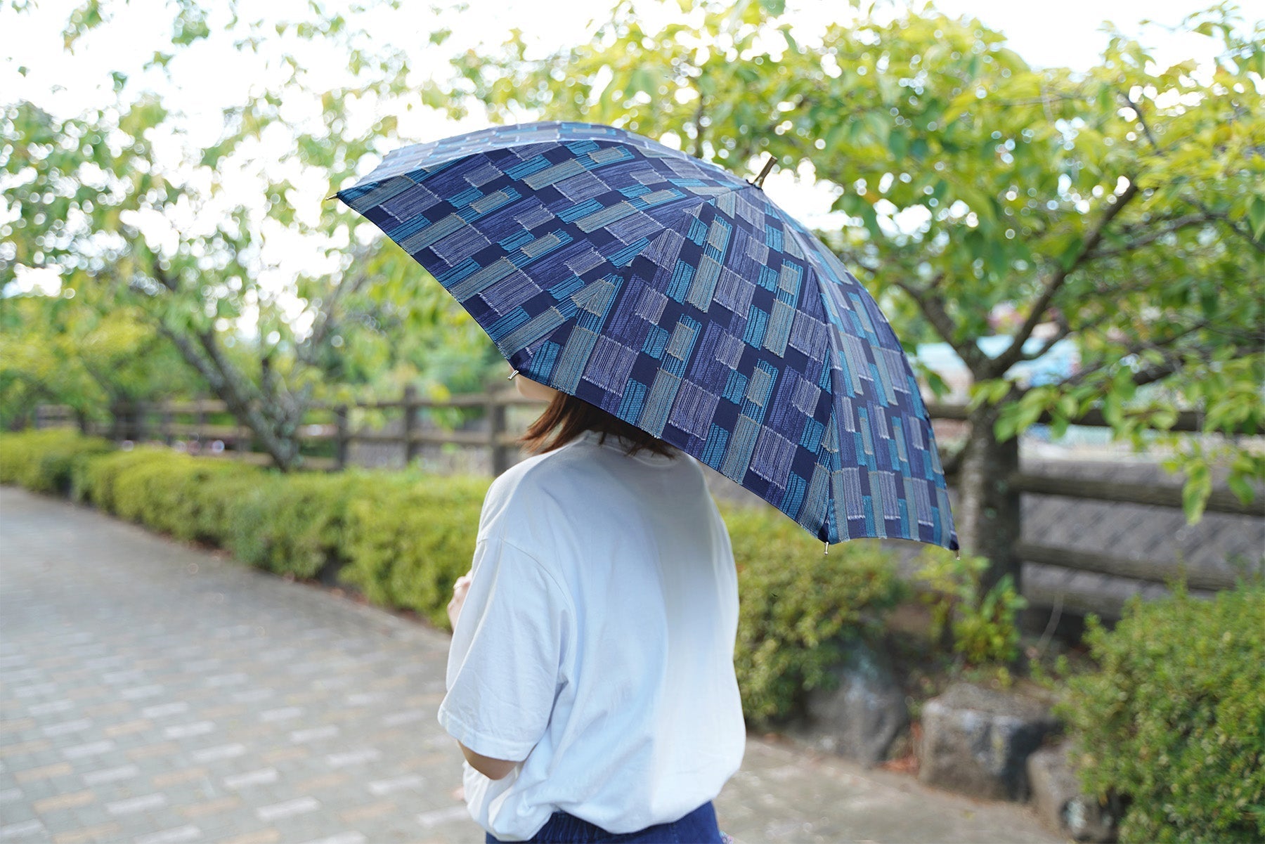 ダークブルー色の日傘を差す女性
